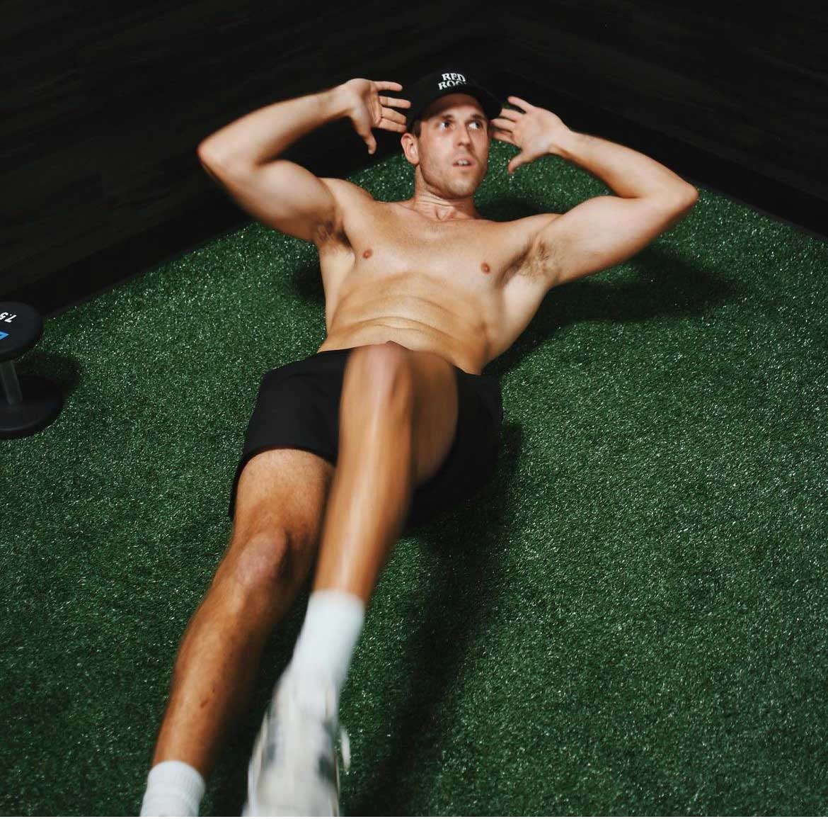 Coach demonstrating a pose on the ground, highlighting abs